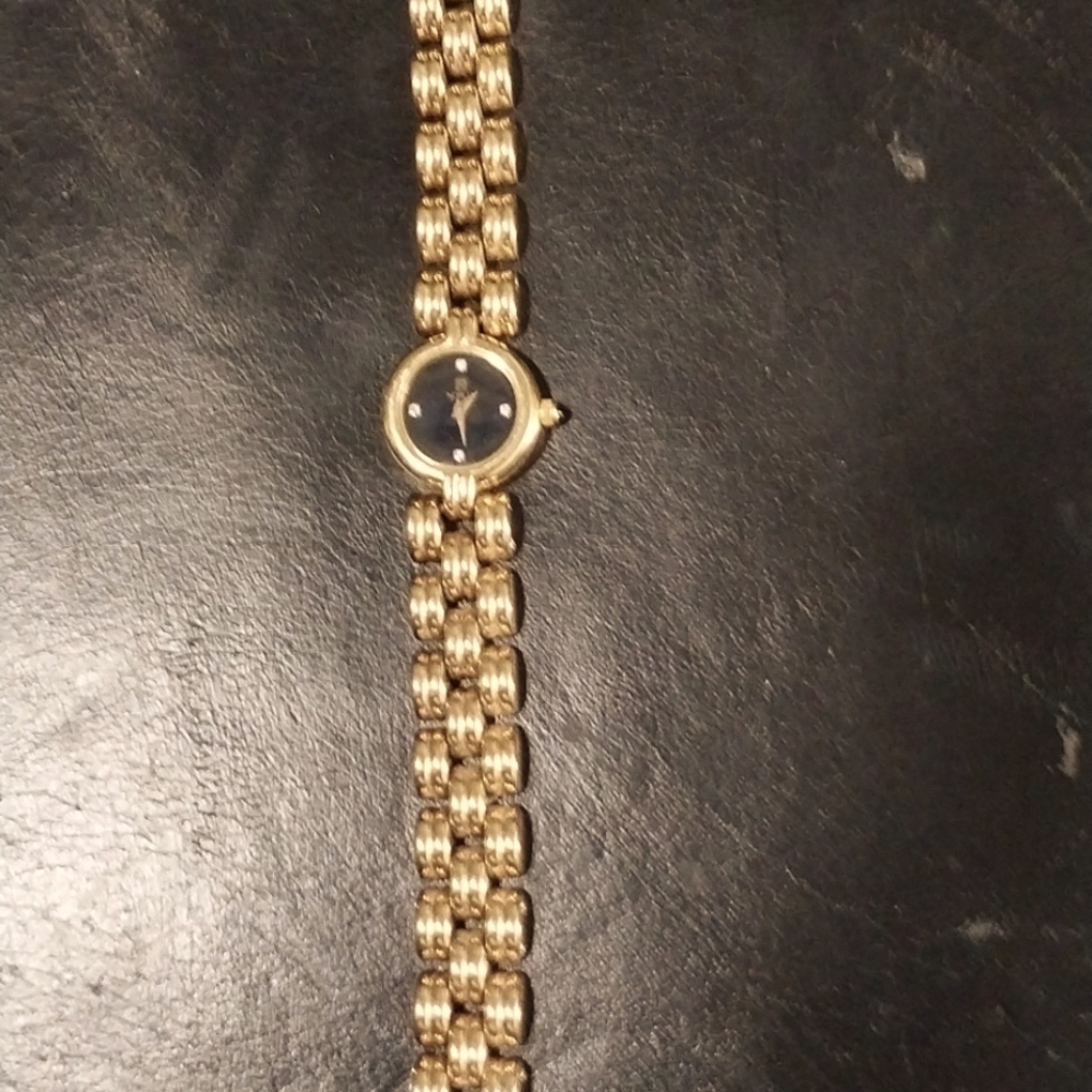 Ladies gold tone watch with black face